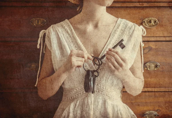 Mulher segurando chave velha e fechadura em uma mão — Fotografia de Stock