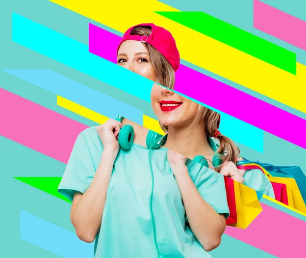 Girl in pink cap and blue t-shirt with shopping bags — Stock Photo, Image