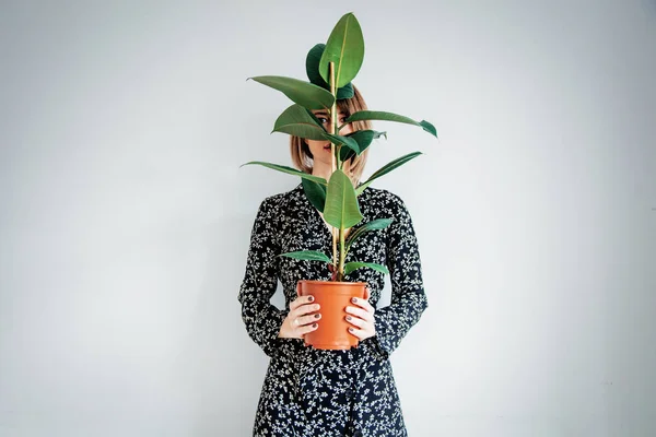 Bella donna in abito alla moda con pianta in una pentola — Foto Stock