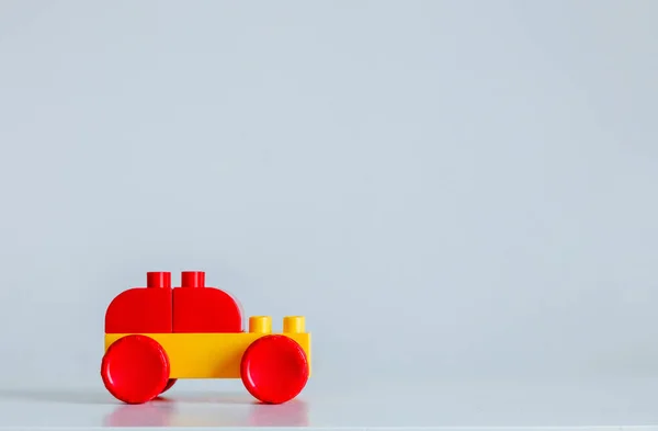 Carro de tijolos de plástico em cor amarela e vermelha em uma mesa — Fotografia de Stock