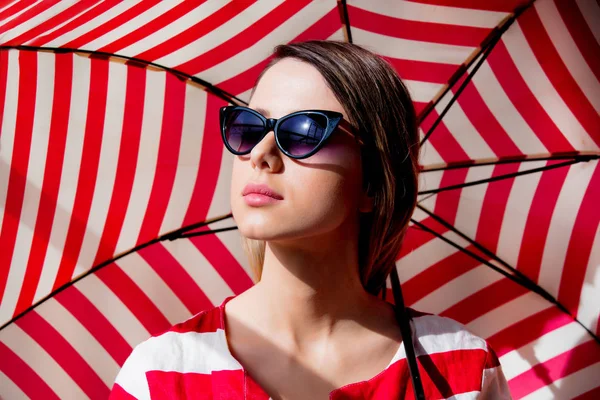 Woman in sunglasses with red striped umbrella — Stock Photo, Image