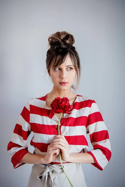 Mujer en camisa rayada holing peonía roja — Foto de Stock