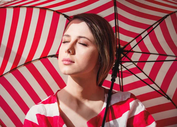 Retrato de una joven con chaqueta y paraguas a rayas . — Foto de Stock