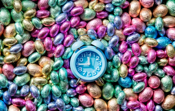 Olor Chocolate Easter eggs and alarm clock on it — Stock Photo, Image