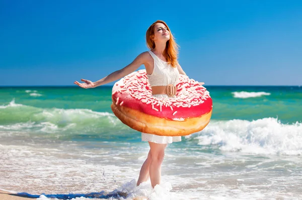 Giovane rossa ragazza con ciambella in vita — Foto Stock