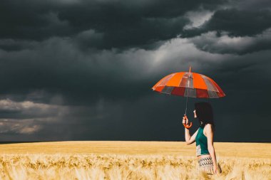 Buğday alan fırtına zamanında şemsiyesi olan kadın