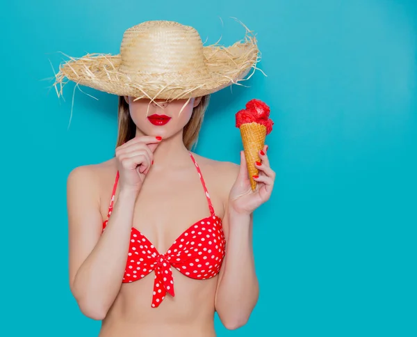 Młoda kobieta w czerwonym bikini i słomkowy kapelusz z lodami — Zdjęcie stockowe
