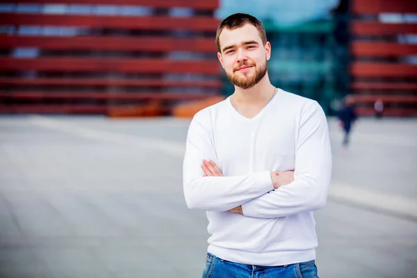 Young man in white seater stay on the city street — Stock Photo, Image