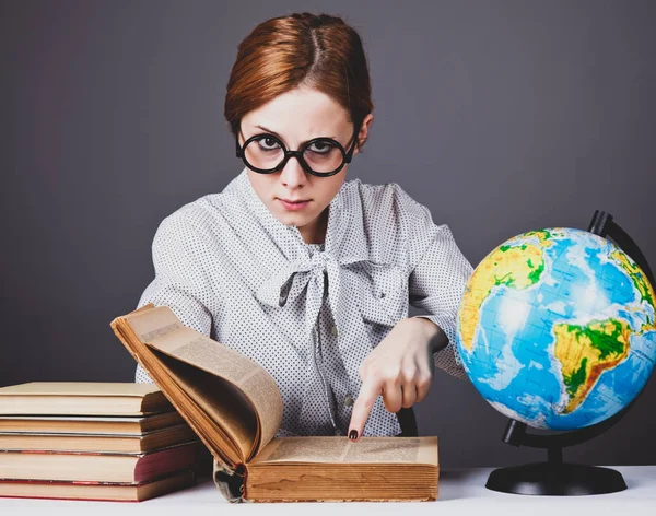 O jovem professor em óculos com livros e globo . — Fotografia de Stock