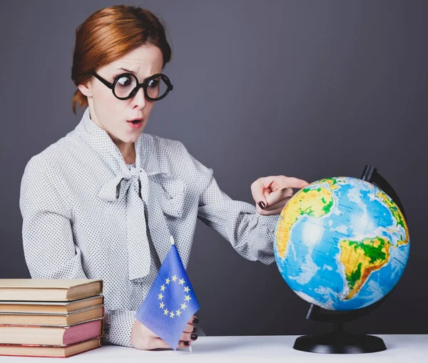 Den unga läraren i glas med böcker, globe och Europeiska Unio — Stockfoto