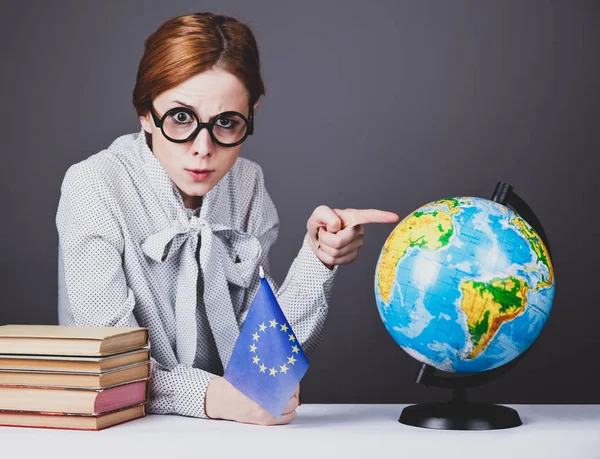 Den unga läraren i glas med böcker, globe och Europeiska Unio — Stockfoto