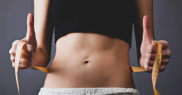 Schöne und starke Frauen & # 039; s Bauch mit Meter. — Stockfoto