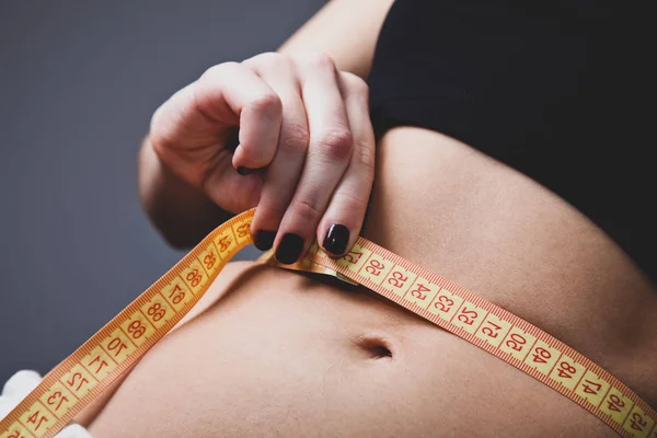 Schöne und starke Bauch der Frau mit Meter. — Stockfoto