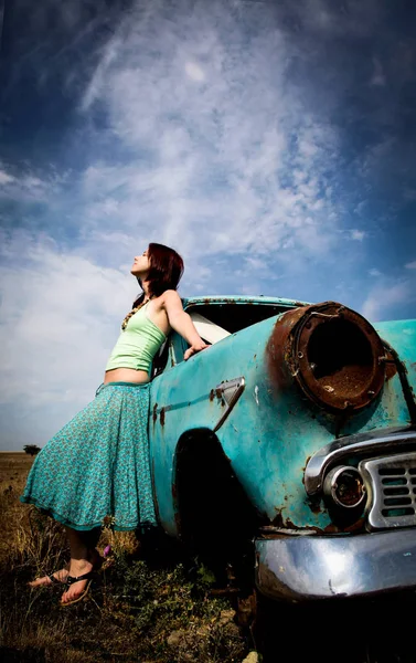 年轻女子住在农村的旧车附近. — 图库照片