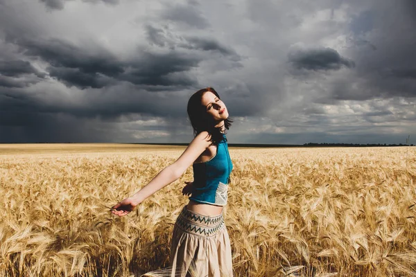 Jong meisje in tarweveld storm tijdig. — Stockfoto