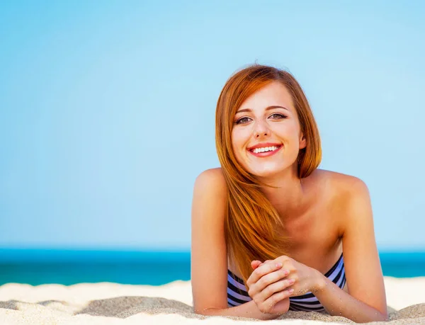 Ragazza rossa sulla spiaggia in primavera . — Foto Stock