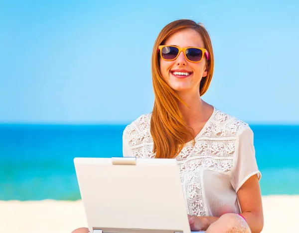 Söt kvinna med vit dator på sommaren stranden — Stockfoto