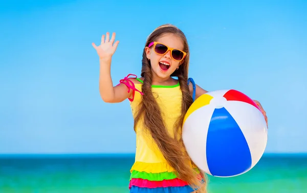 Liten flicka som leker på stranden med boll. — Stockfoto