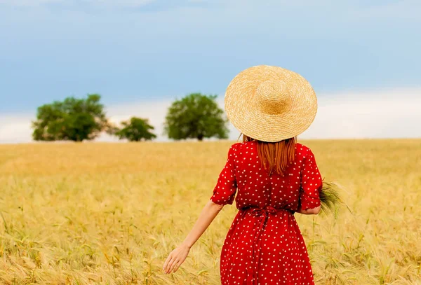 Rödhårig flicka i röd klänning på vete fält — Stockfoto
