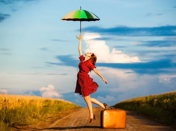 Vrouw met reizen siutcase op weg van het platteland — Stockfoto