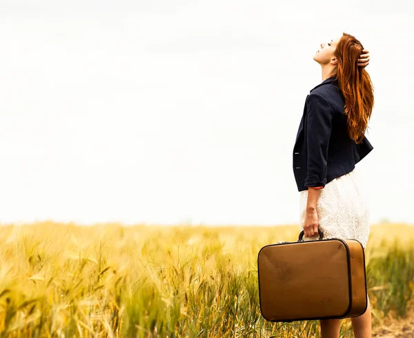 Rothaarige Mädchen mit Koffer im Freien. — Stockfoto