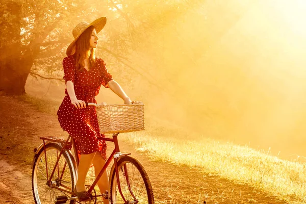 Girl on a bike in the countryside in sunrise time — Stock Photo, Image