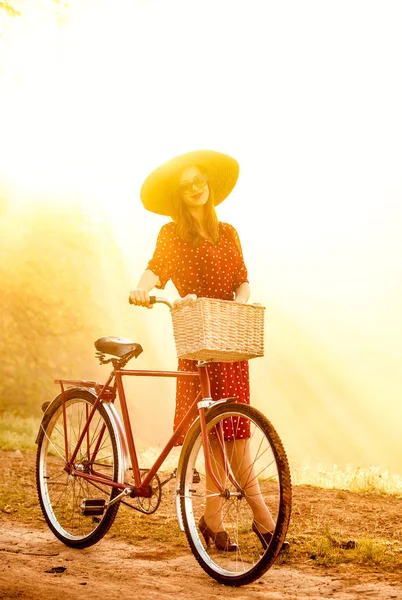 Girl on a bike in the countryside in sunrise time — Stock Photo, Image