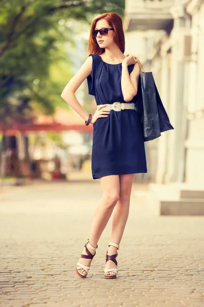 Young woman with shopping bags walking on the city street Stock Photo