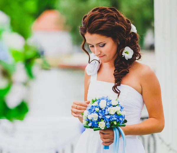 花の花束を持つ若い花嫁の肖像画一个年轻的女孩与花在背景中的一幅肖像. — ストック写真