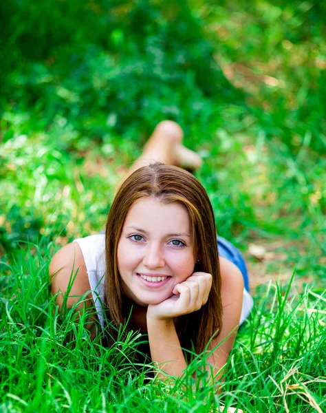 Όμορφο κορίτσι εφήβων στο πάρκο στο πράσινο γρασίδι. — Φωτογραφία Αρχείου