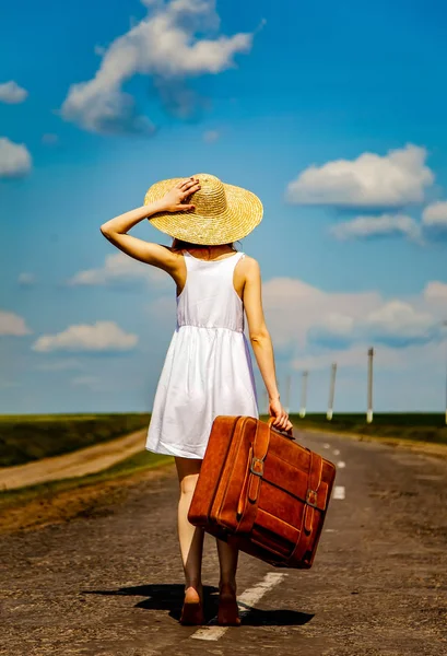 Lonely girl with suitcase at country road. — Stock Photo, Image