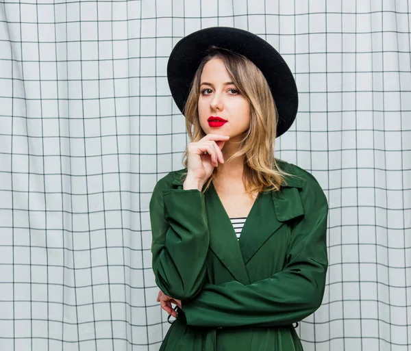 Mladý styl žena v klobouku a zelený plášť v 90s stylu — Stock fotografie