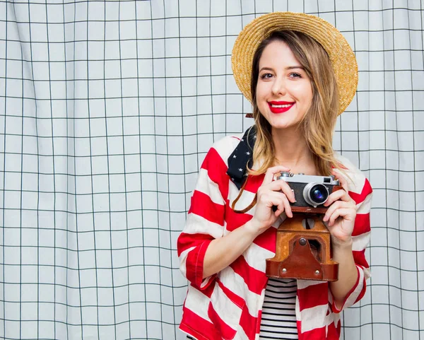 Vrouw in hoed en gestreept vest met vintage camera — Stockfoto