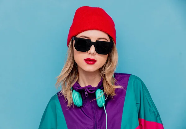 Femme en chapeau rouge, lunettes de soleil et costume des années 90 avec écouteurs — Photo