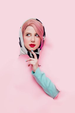 Şal ve mavi klasik ceket güzel kadın yırtılmış kağıt formu görünüyor. Pembe bir arka plan 