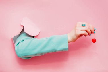 Pembe arka plan el kiraz ile klasik mavi ceketli bakıyor