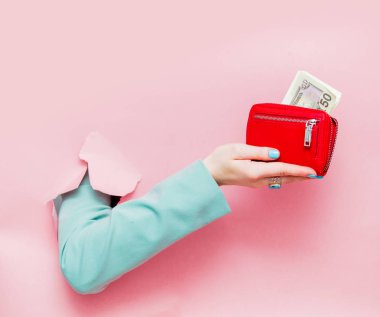 Pembe arka plan el klasik mavi ceket Haritayı Doları çanta içinde bakıyor
