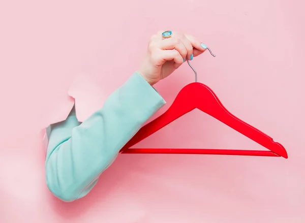 Mano femenina en chaqueta clásica azul con percha — Foto de Stock