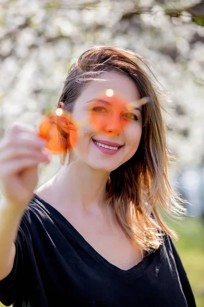 Menina em um óculos de sol ficar perto de uma árvore de floração — Fotografia de Stock