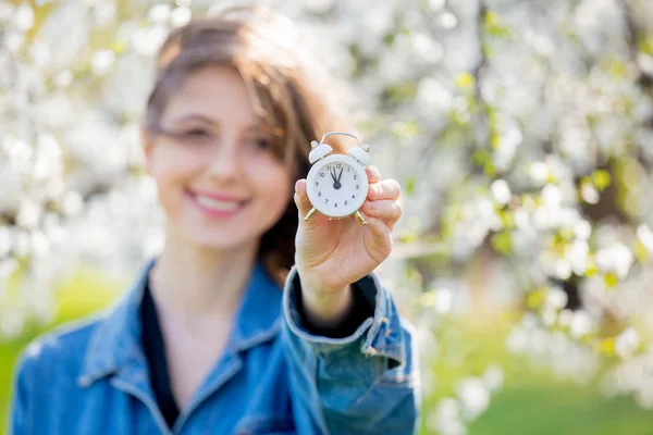 Bir denim ceket ve çalar saat kız bir çiçekli t yakınında duruyor — Stok fotoğraf