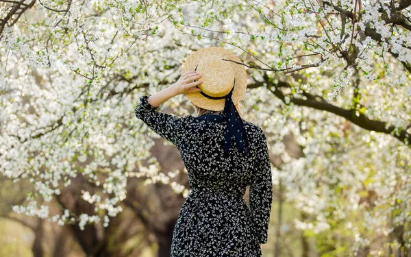꽃 나무 근처의 모자에서 어린 소녀 — 스톡 사진