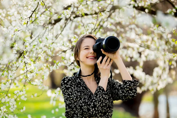 Dziewczyna z profesjonalnym aparatem fotograficznym robienia zdjęć z kwiaciarniehortensjenaturawszystkopodestynicearoślinytłamoja — Zdjęcie stockowe