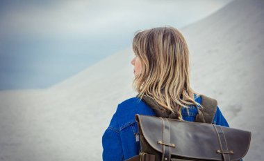 Bahar zamanında kum sahilde sırt çantası ile Seyahat kız.