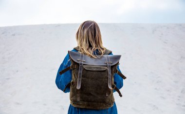 Bahar zamanında kum sahilde sırt çantası ile Seyahat kız.