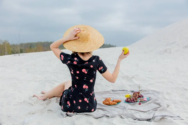 Κορίτσι κάθεται σε σκουπίδια και να κρατήσει ένα μήλο σε ένα χέρι. — Φωτογραφία Αρχείου