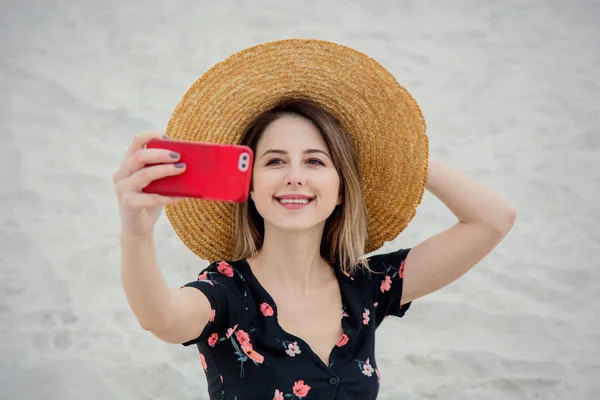 Mulher bonita tem em chapéu com telefone celular fazer uma selfie em um — Fotografia de Stock