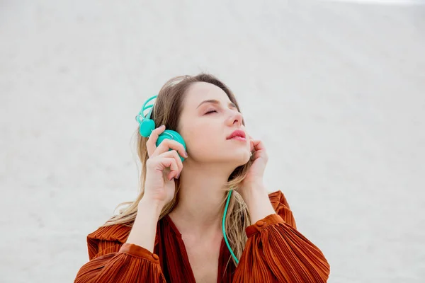 Young woman in burgundy color blouse with headphones — Stock Photo, Image