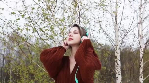 Stijl Volwassen Vrouw Met Koptelefoon Bourgondische Kleur Blouse Berken Bomen — Stockvideo