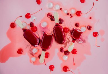 pembe arka plan üzerinde ahududu ve kiraz buz lollys