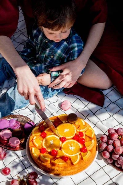 Kobieta wyciąć ciasto z pomarańczy na dzień imprezy na piknik chacked ll — Zdjęcie stockowe